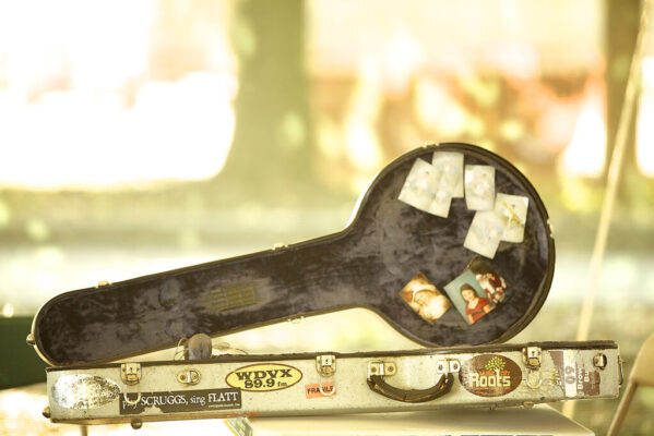 A banjo case decorated with various photos and stickers