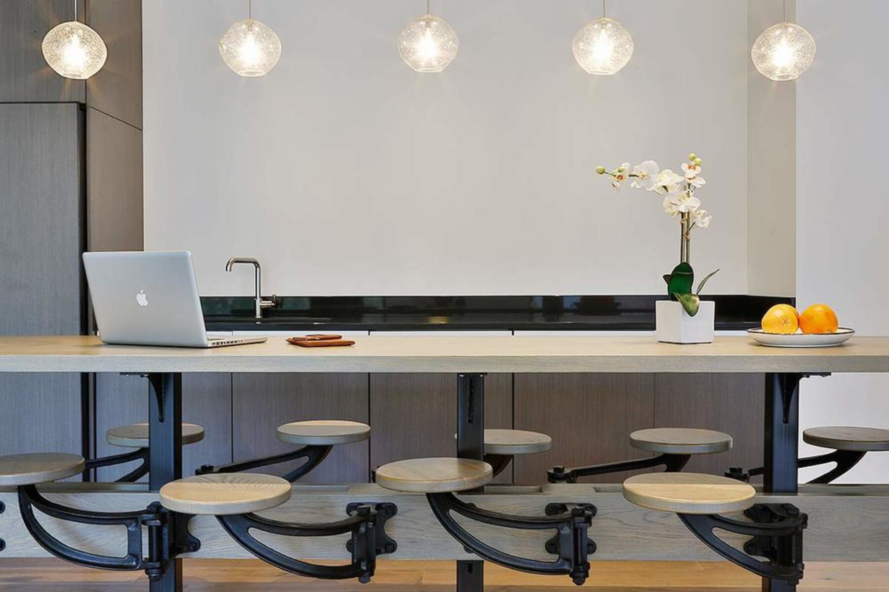 A modern kitchen with a Macbook on the table