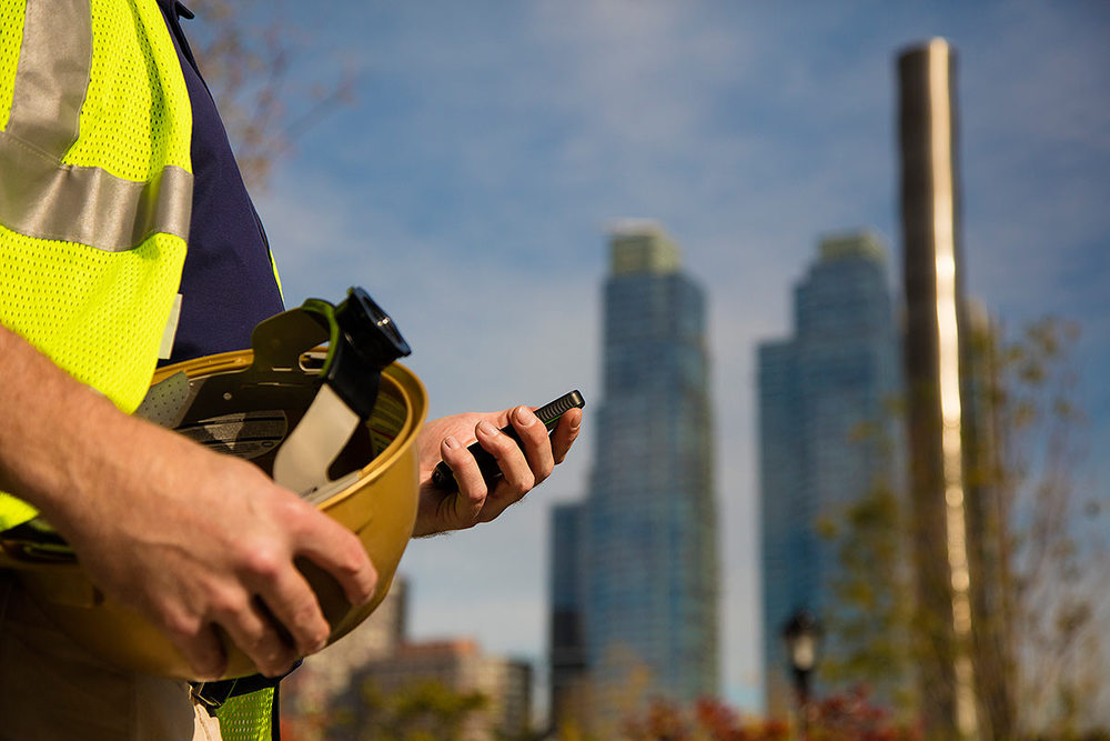 A construction worker looking at a device