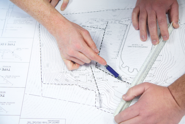 People mapping out plan using pen and ruler