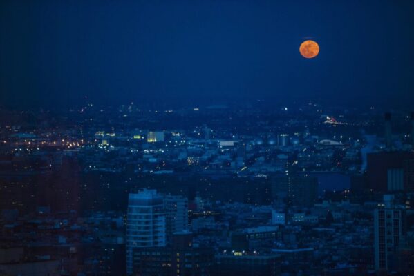 Night time view of the city with an orange moon