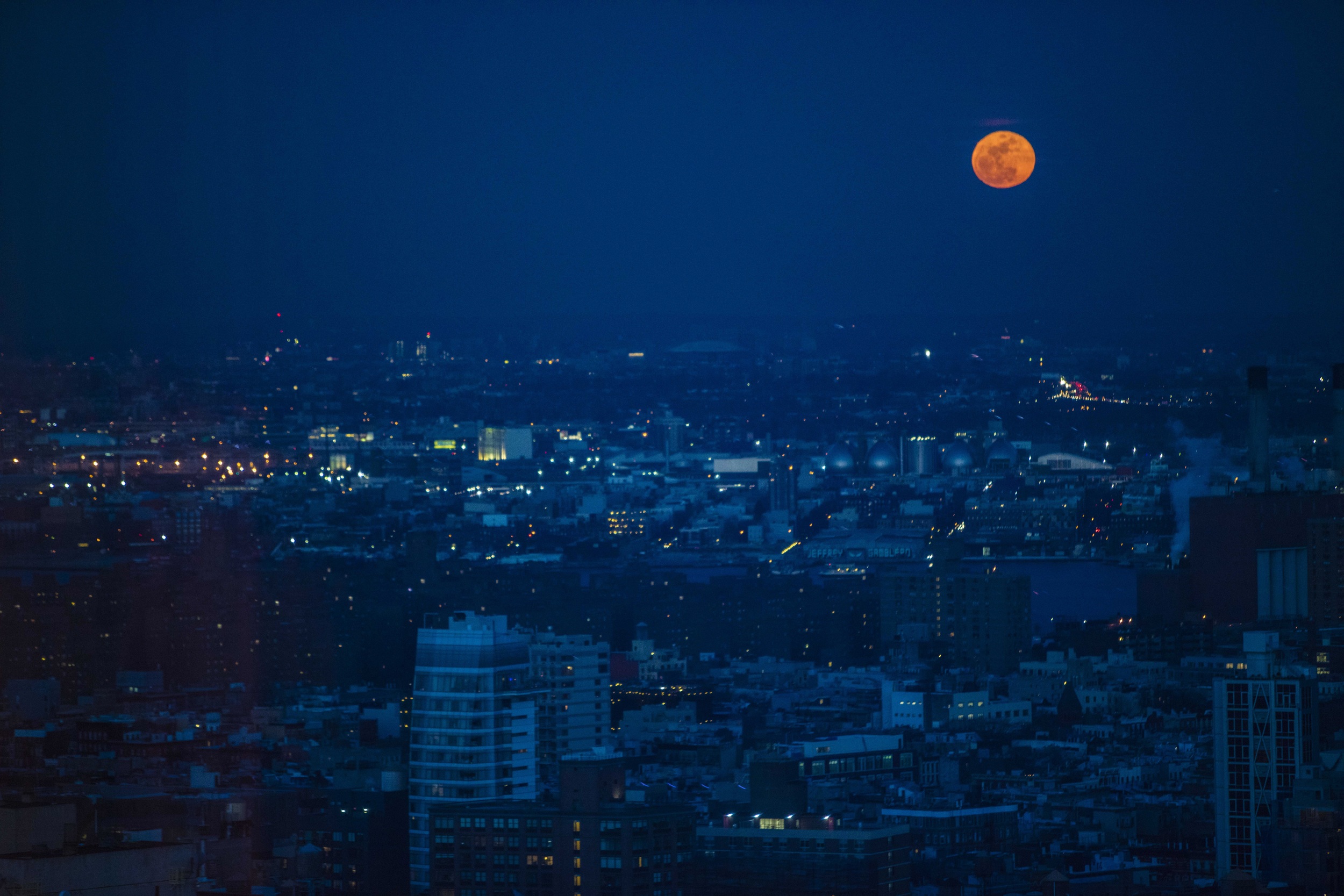 Night time view of the city with an orange moon