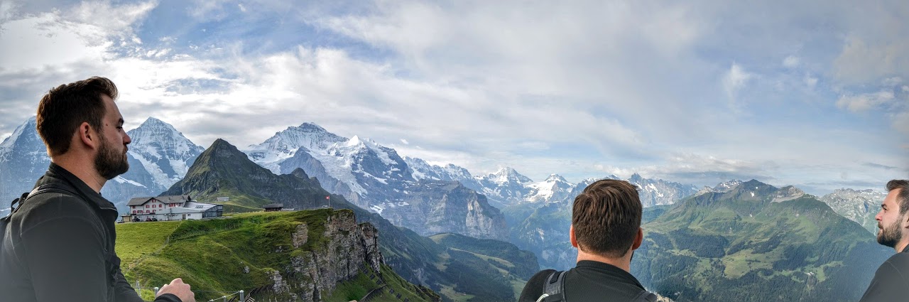 3 men looking at mountains during the day