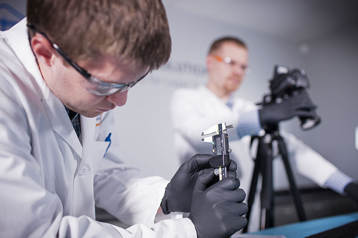 Photograph of scientists work in a lab using forensic equipment.