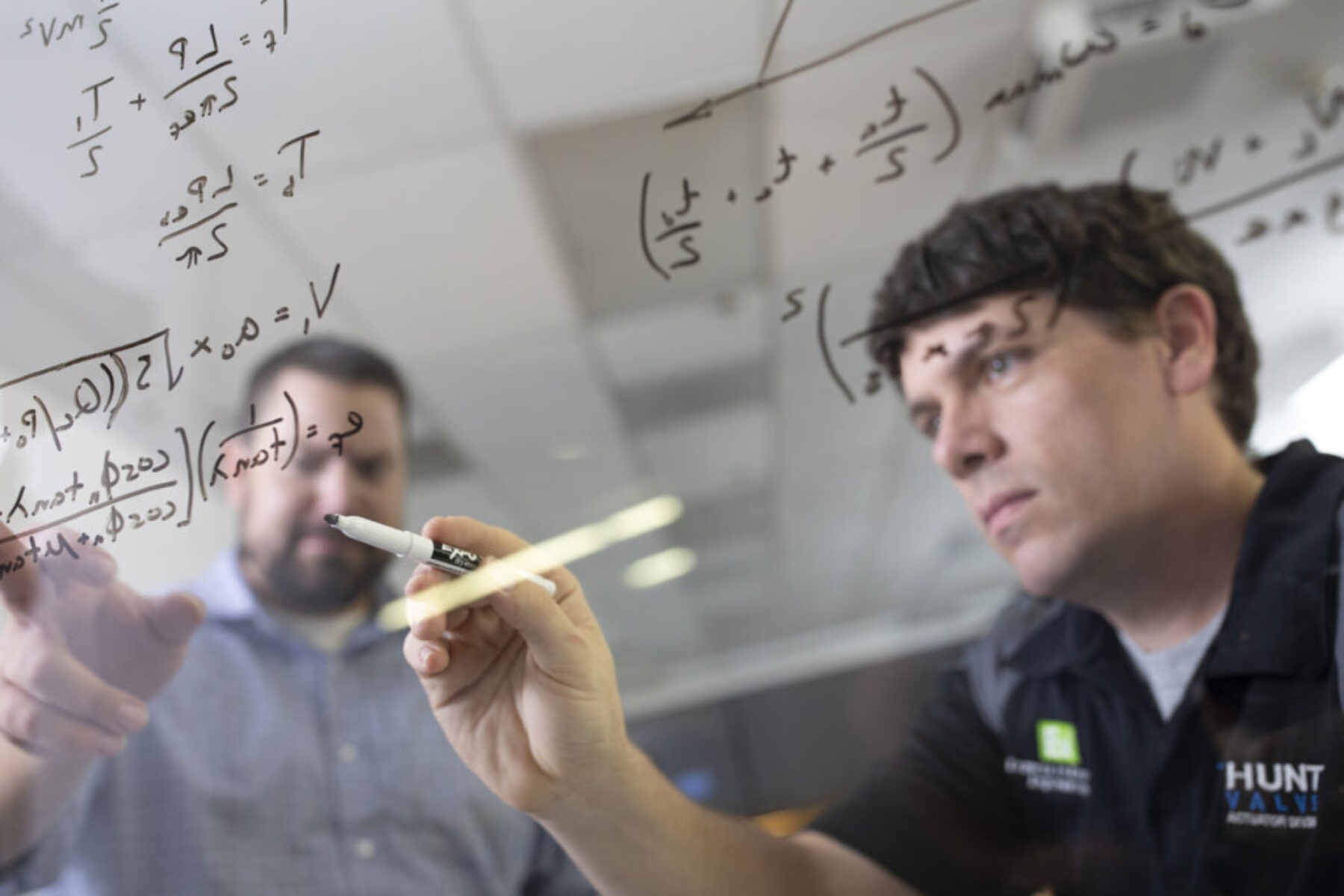 Two men working on equations with one another