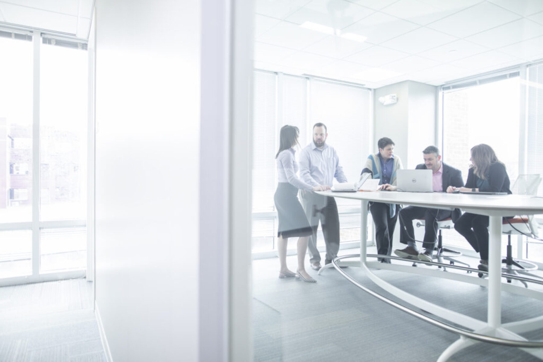 Five people in a conference room strategizing