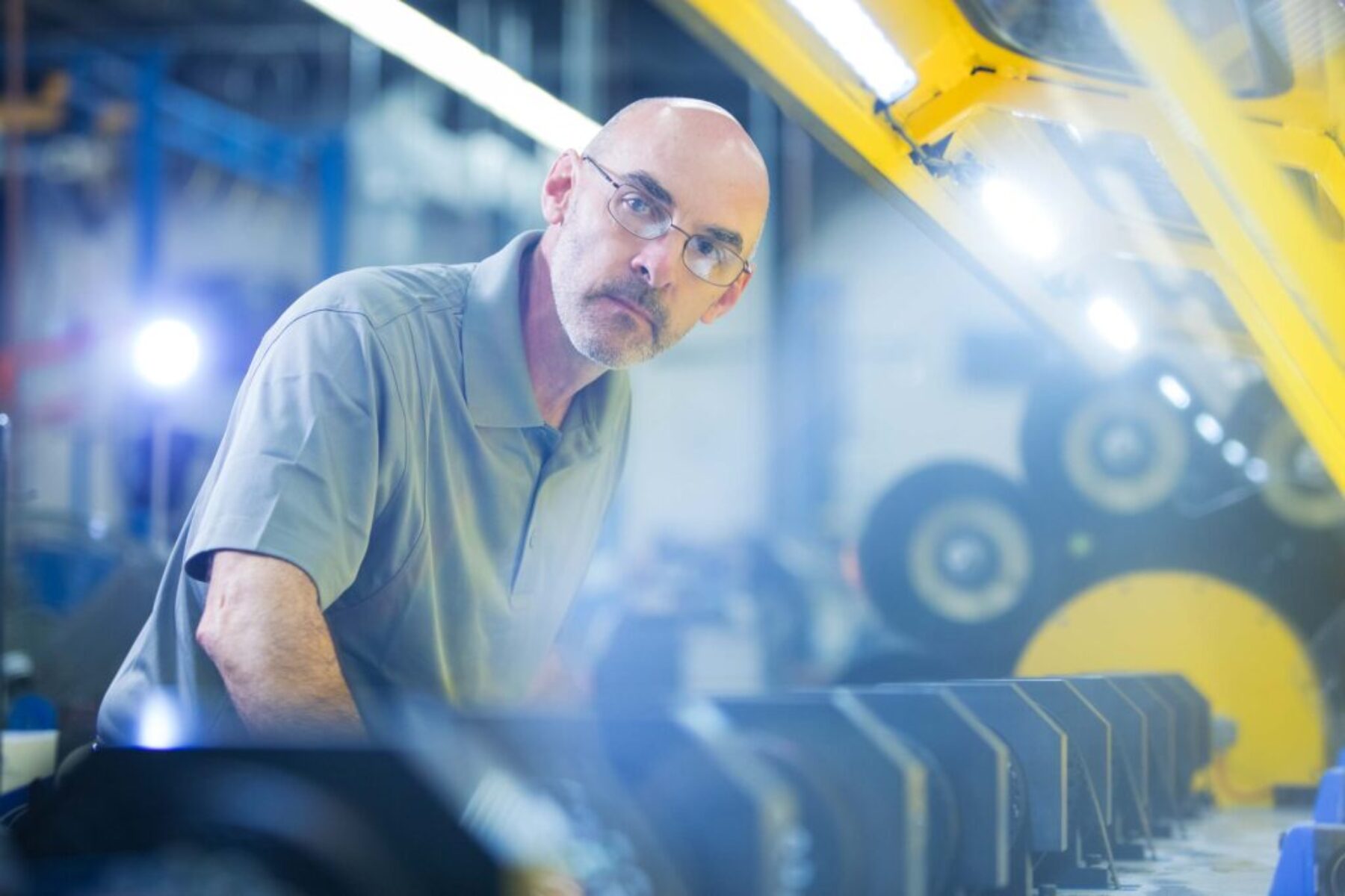 Engineer Inspecting Production Line – Industrial Photography Engineer inspecting machinery inside a manufacturing facility.