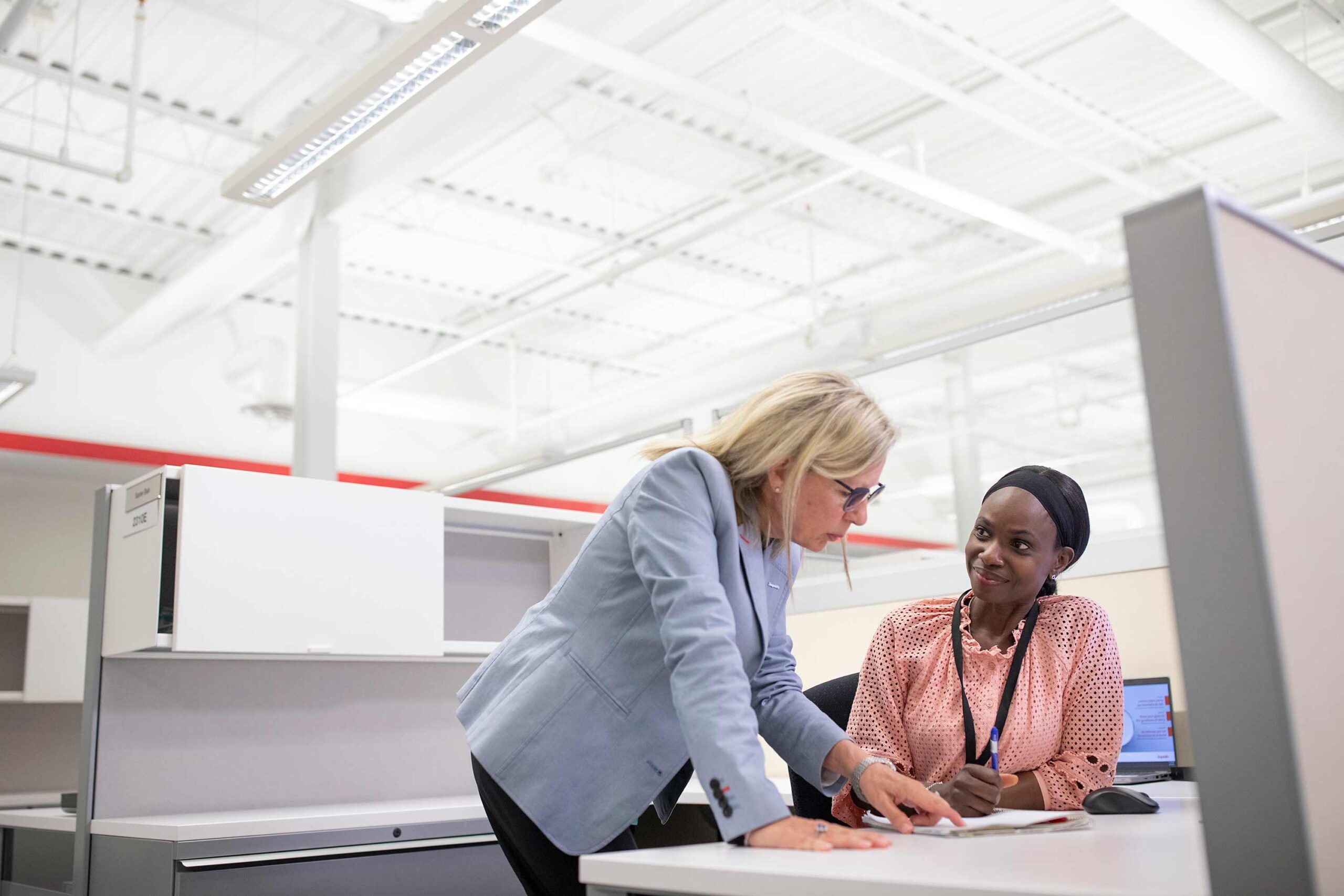 Brand Photography — Office Collaboration Scene Brand photography of two professional women collaborating in a bright, modern office.