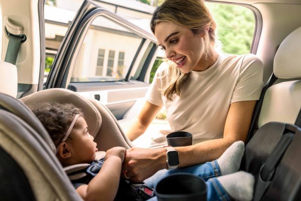 Bright, warm lifestyle commercial image showcasing authentic parent and child bonding featuring a modern luxury car seat.