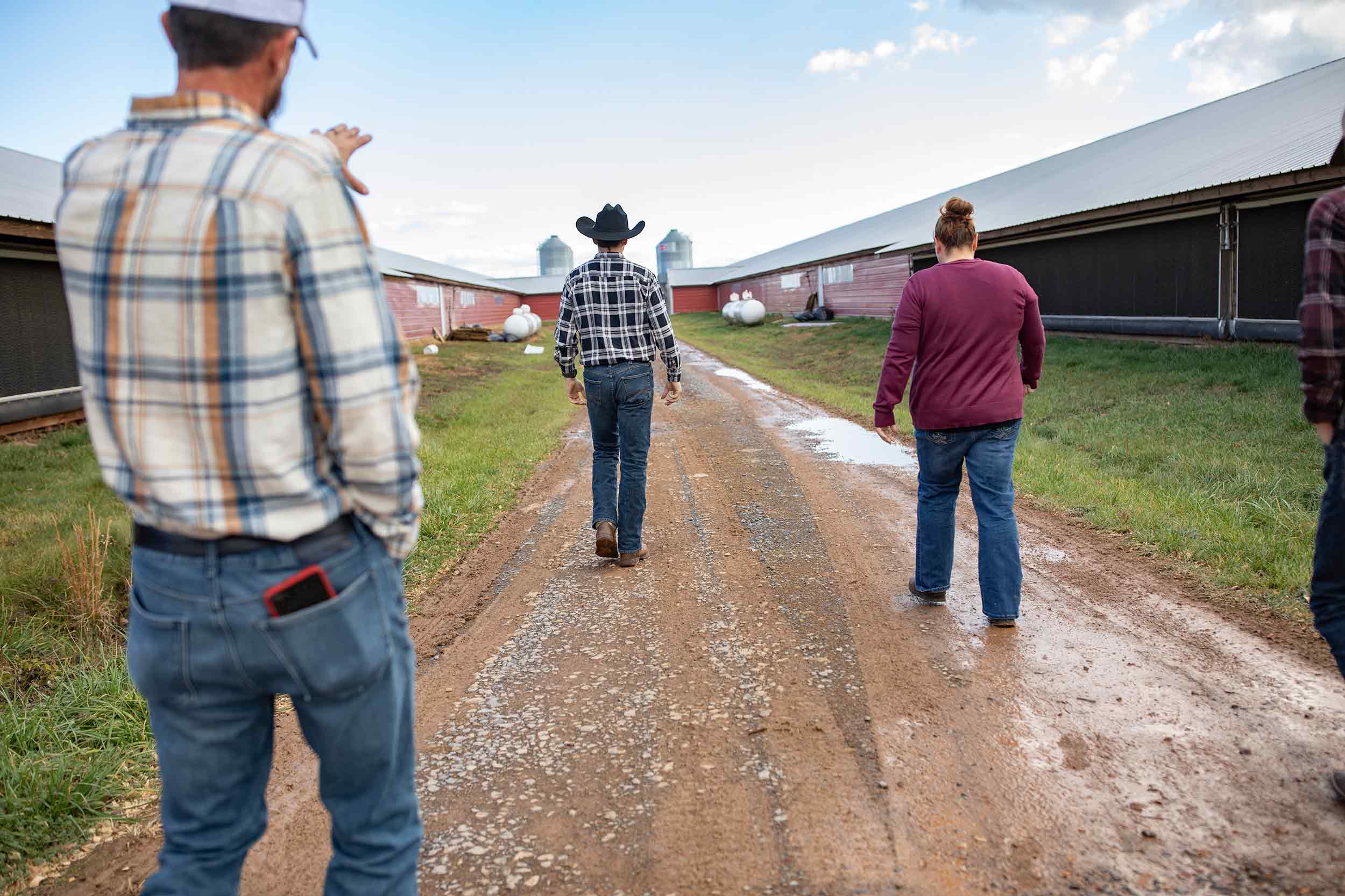 Farmer Focus farmers walking between poultry houses on a working farm.