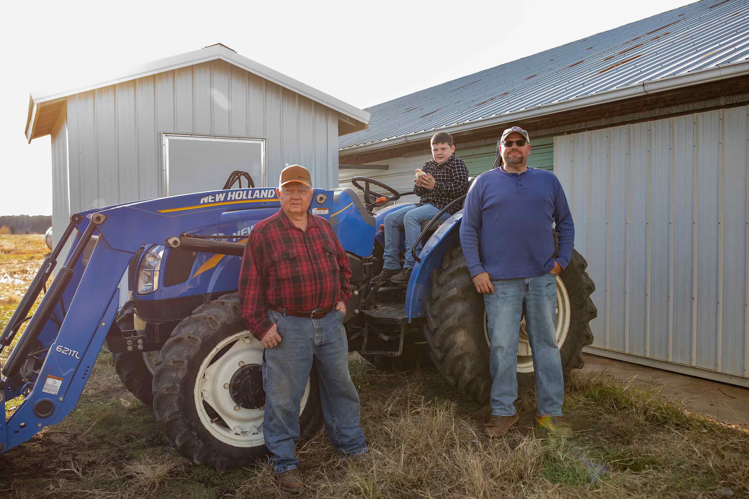 Three generations of a Farmer Focus farm family photographed with their tractor.