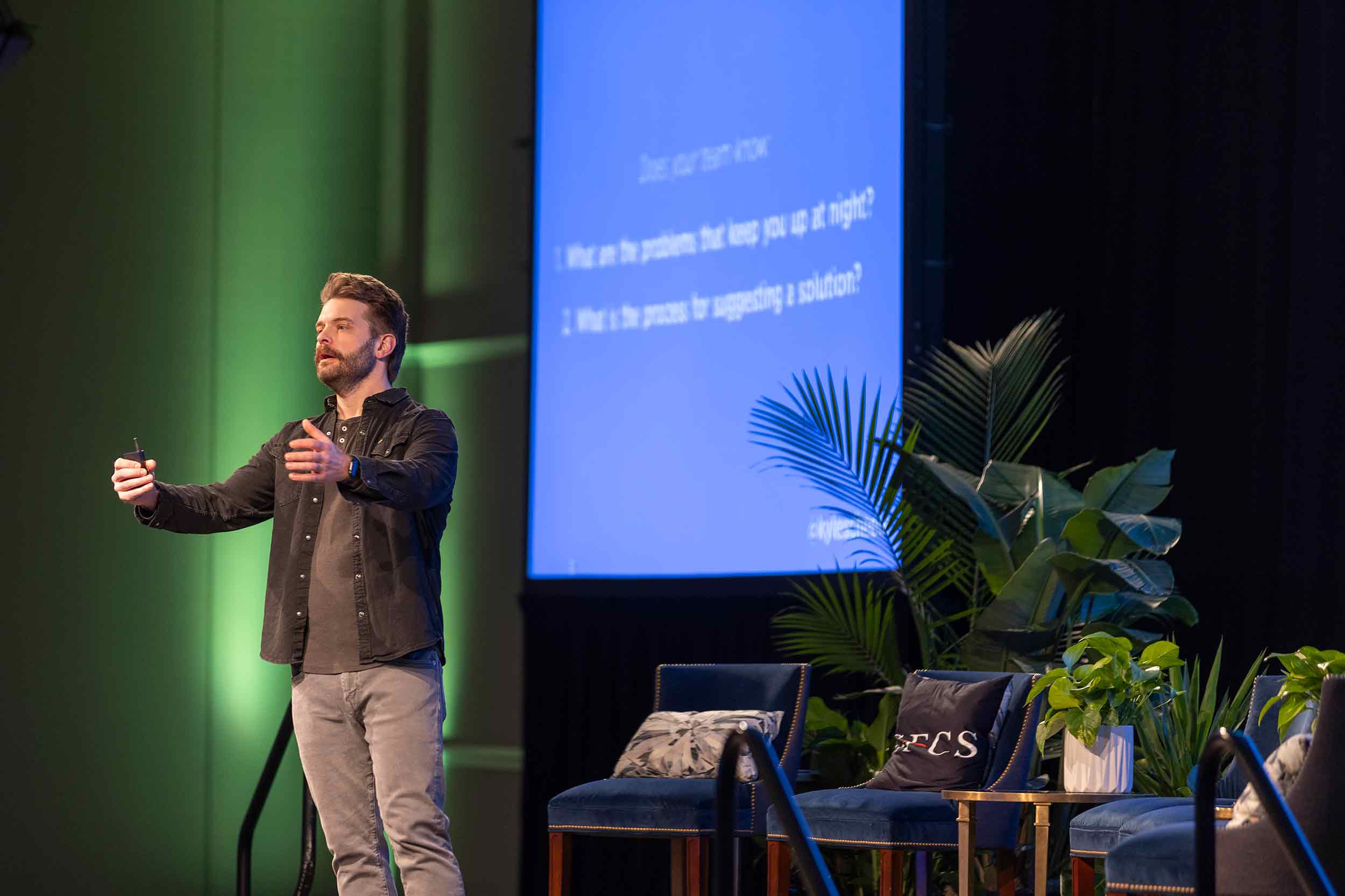 Speaker presenting on stage at the SFCS By Design conference