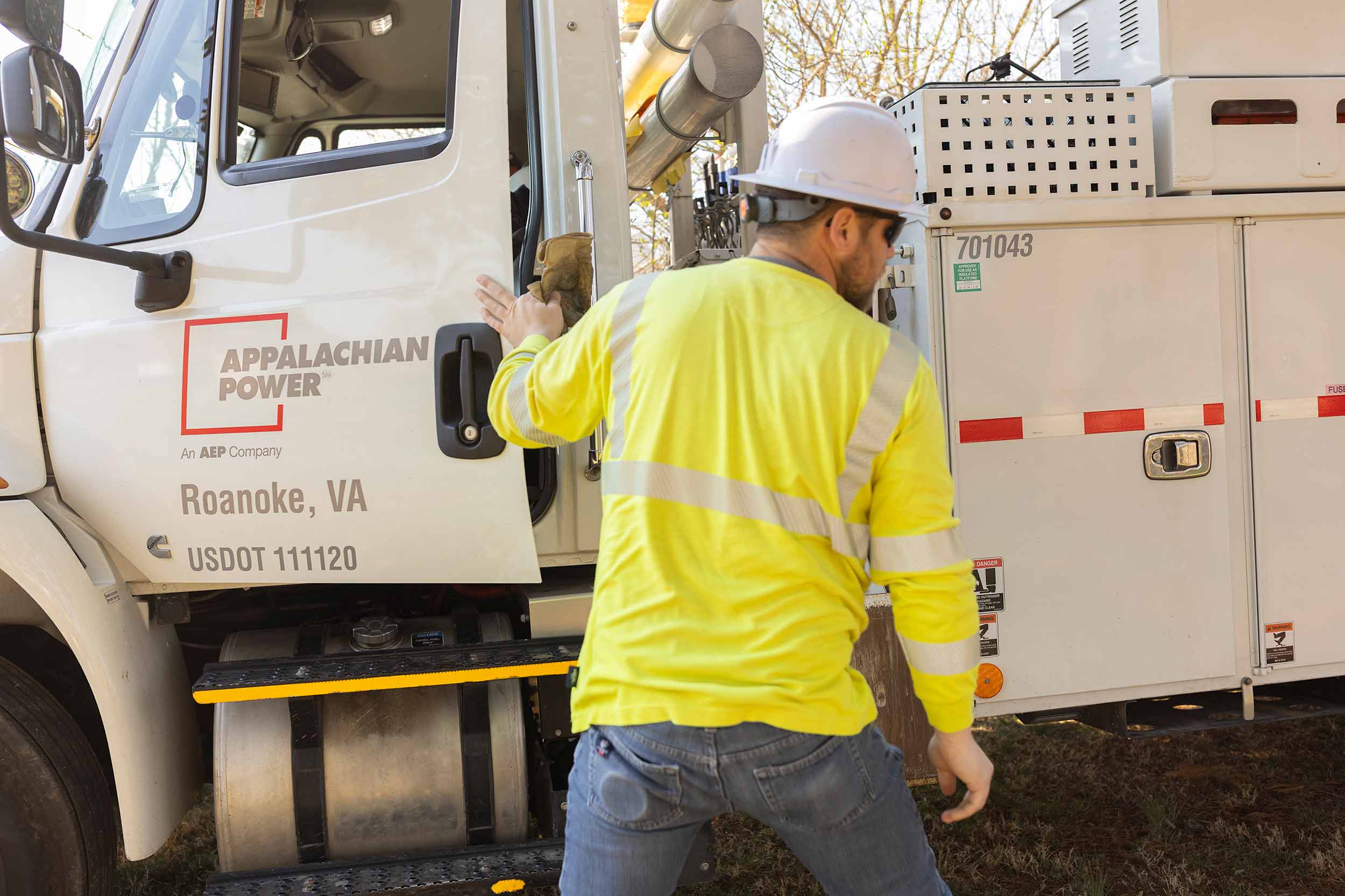 Appalachian Power utility worker in high-visibility safety clothing beside a service truck in Roanoke, Virginia.