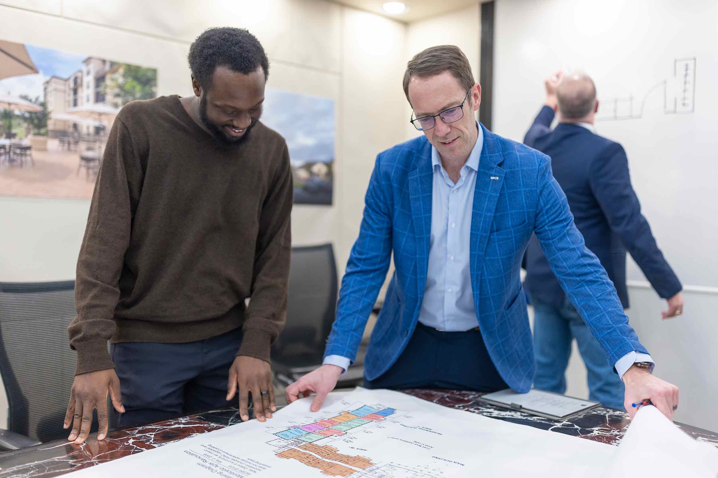 SFCS Architects team reviewing building plans during a design meeting